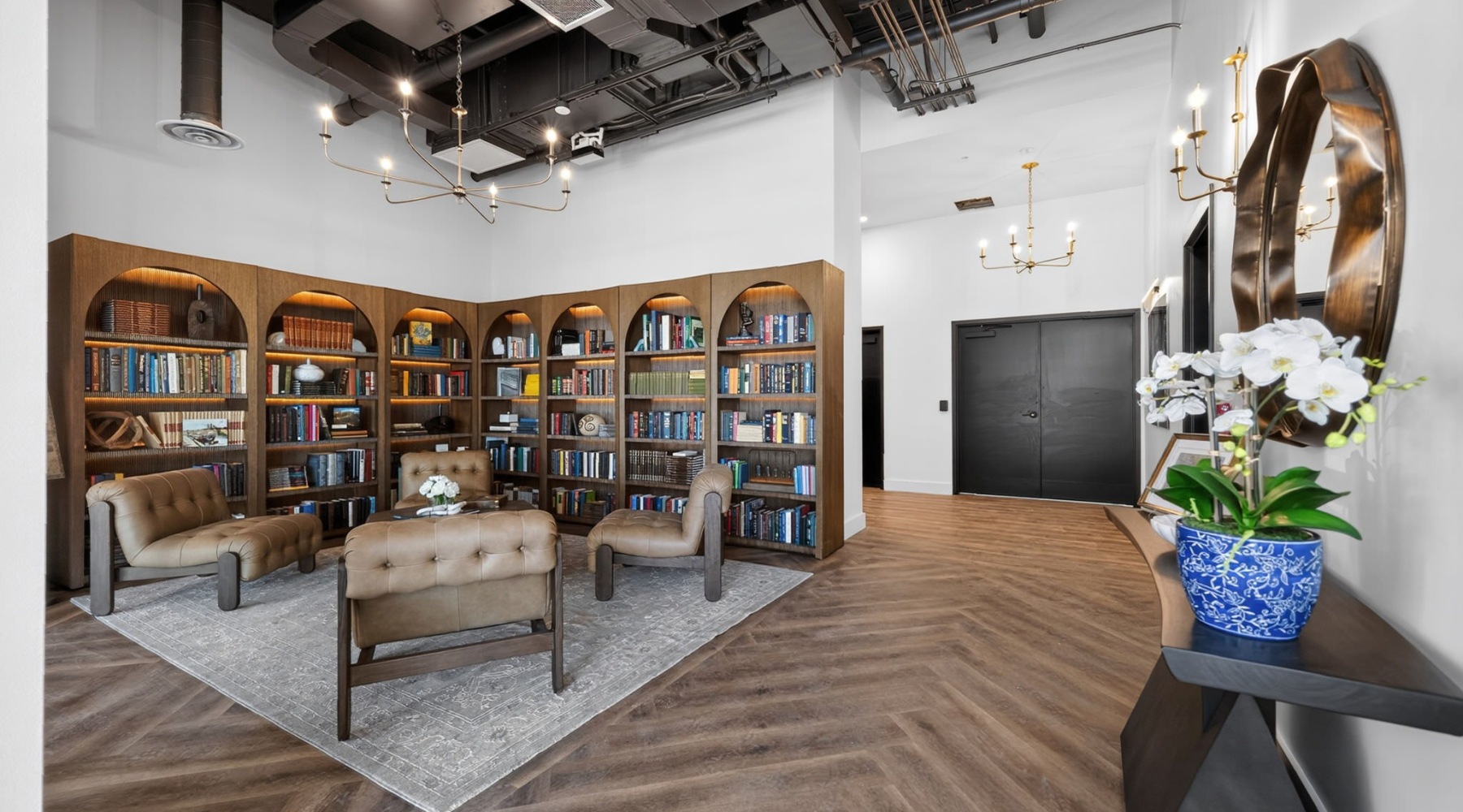a library with chairs and wood floors